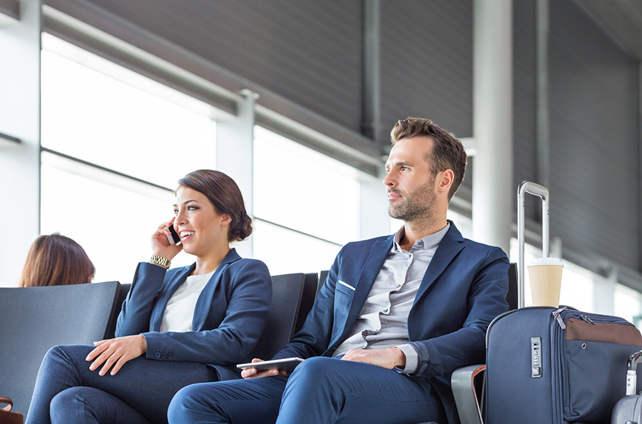 Man and woman at airport awaiting flight.