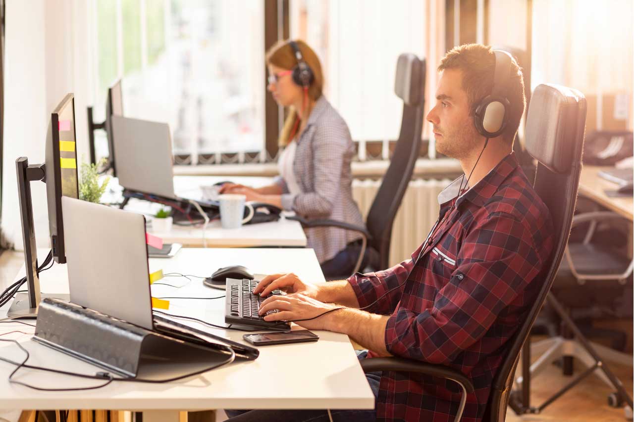 Man and woman at their computers working as a client’s helpdesk