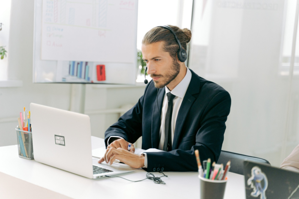 a man working on a laptop while headset and mic